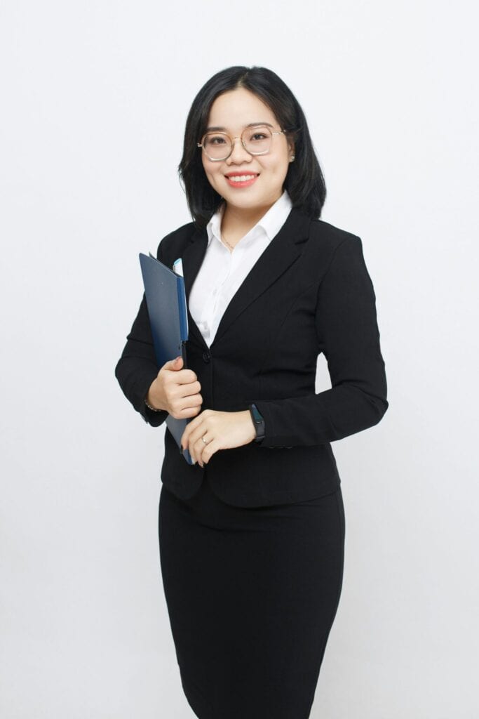 CFO wearing a suit standing with a file in her hands, smiling
