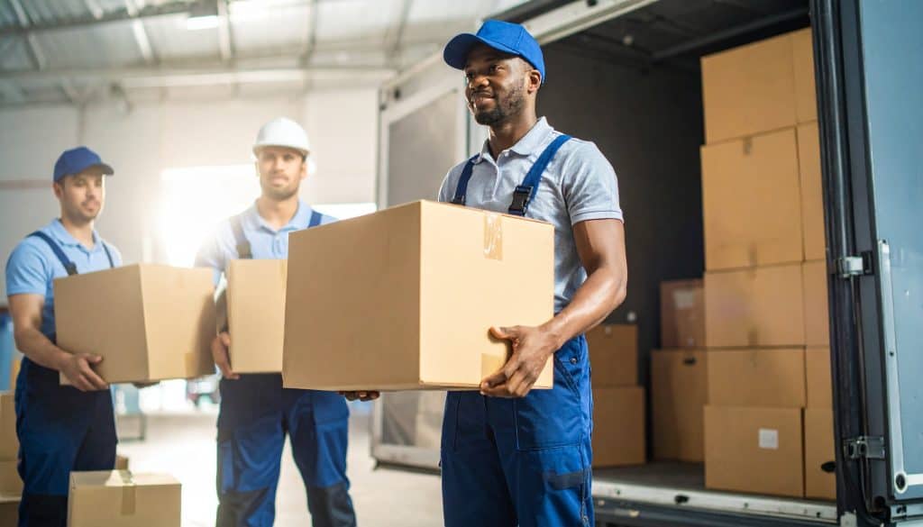 Three male inventory services professionals unload boxes from car